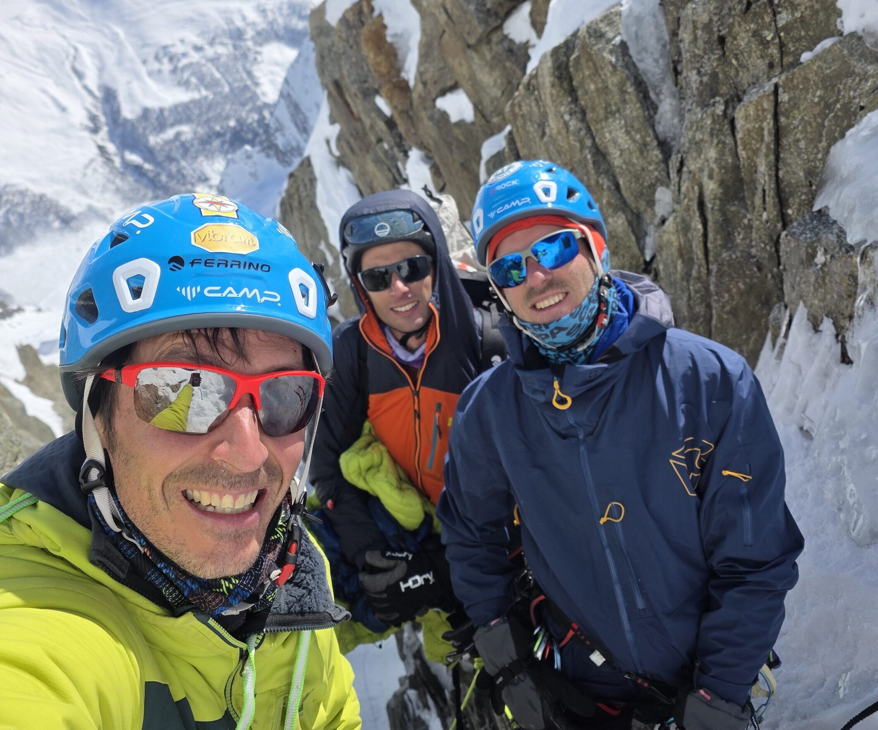 Climbers smile on the top of a couloir at the Mont Blanc massif.