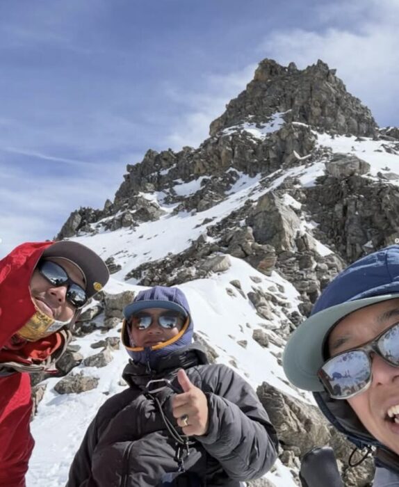 Climbers in front of a rocky summit. 