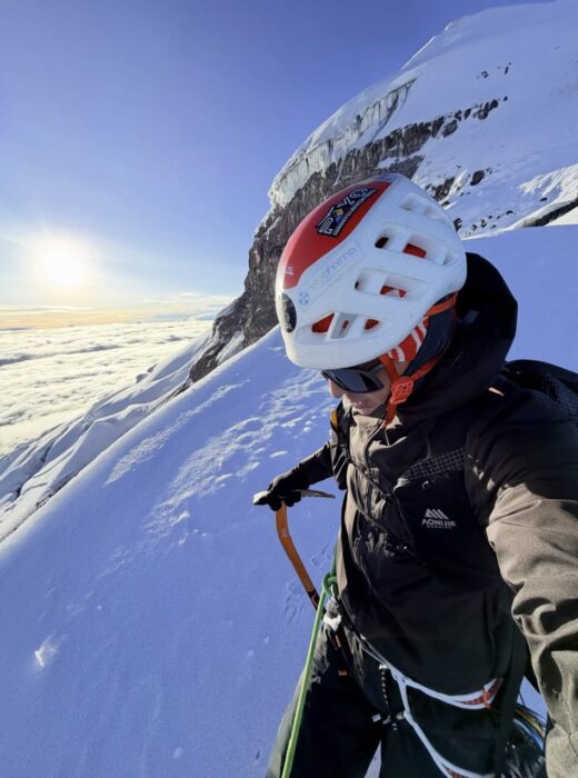 A climber takes a selfie on Cotopaxi's summit area at dawn.