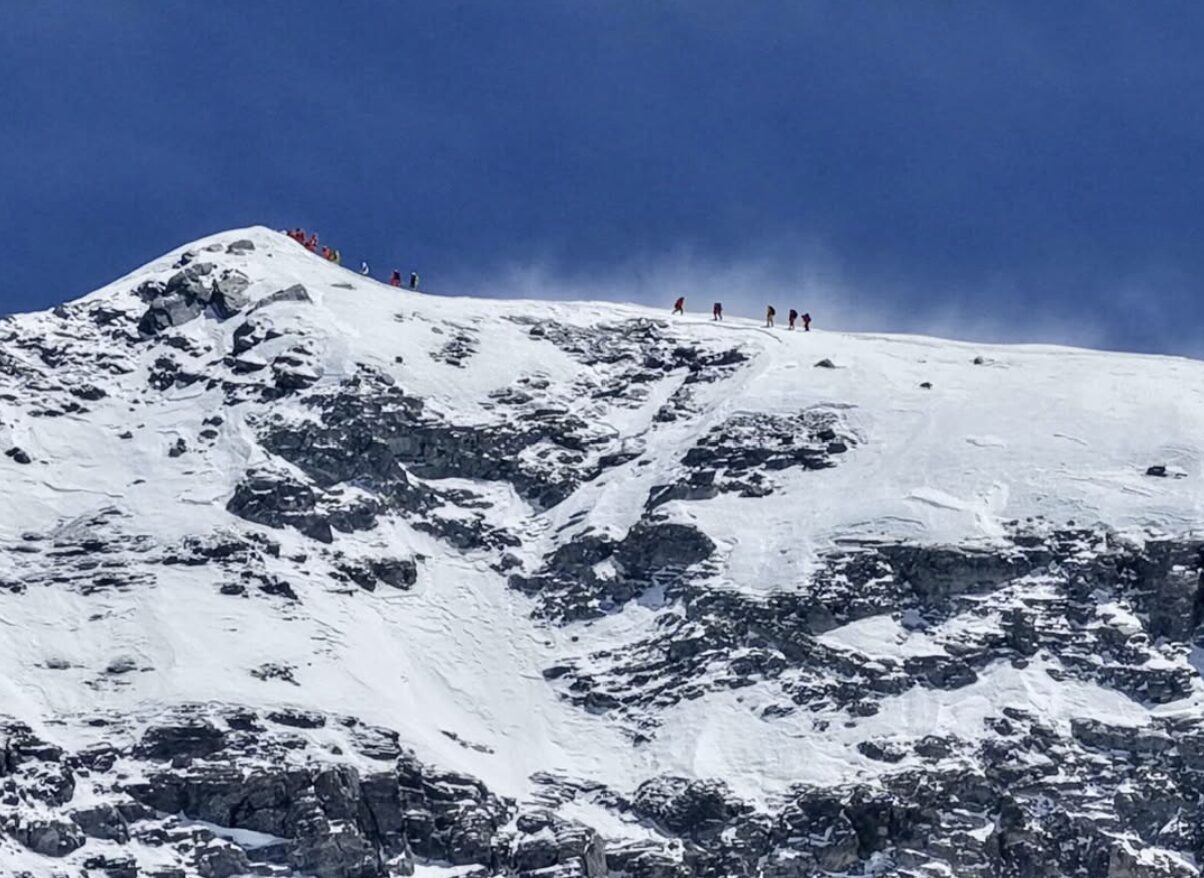 Climbners about to reach the summit of Everest today, along a windy ridge.