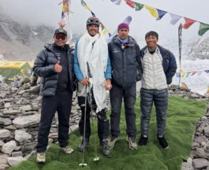 Four people posing in everest BC by a chorten