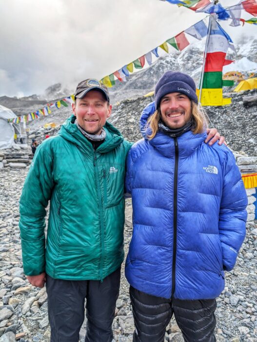 Two climbers standing up at Everest BAse Camp.