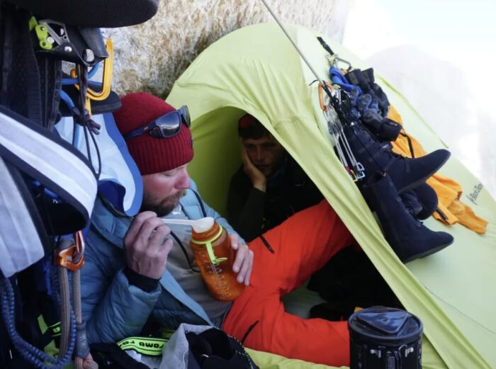Climbers at a bivy on a mountain face.