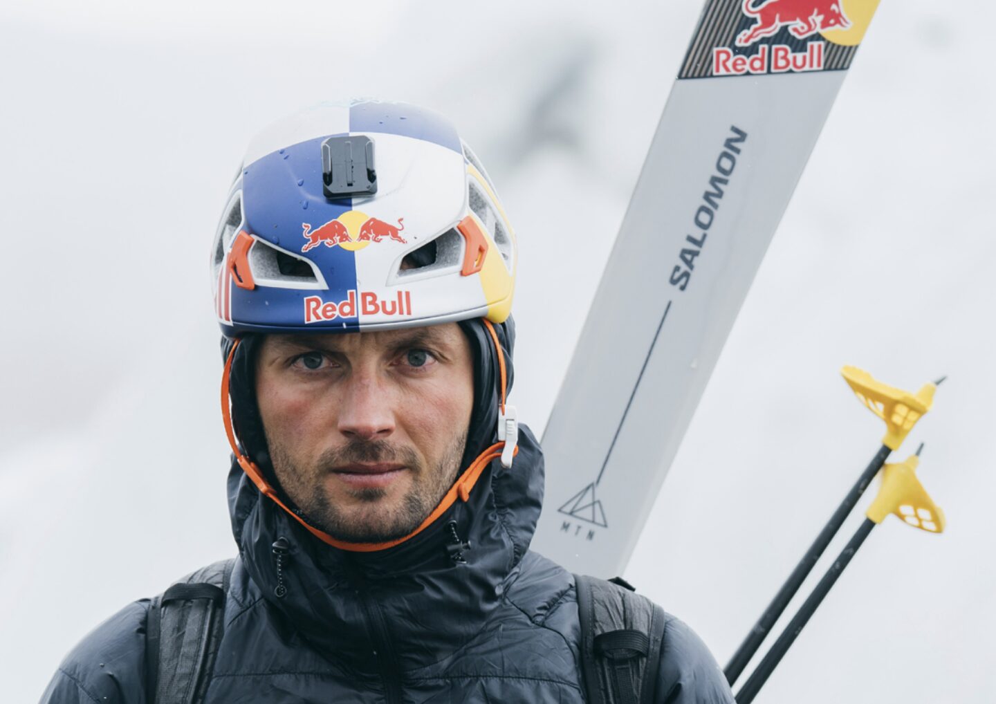 Close shot of Polish skier Andrzej bargiel with helmet and his skis on his backpack.