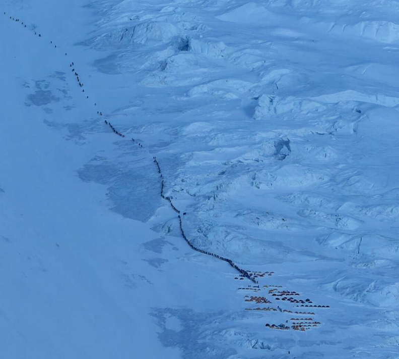 line of climbers in blue twilight light