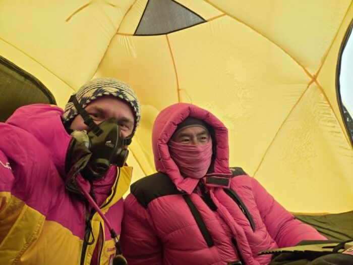 A foreigner on O2 and a Sherpa without inside a tent.