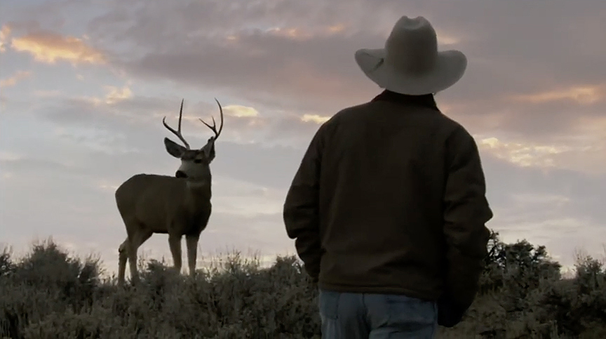 silhouette of man and mule deer