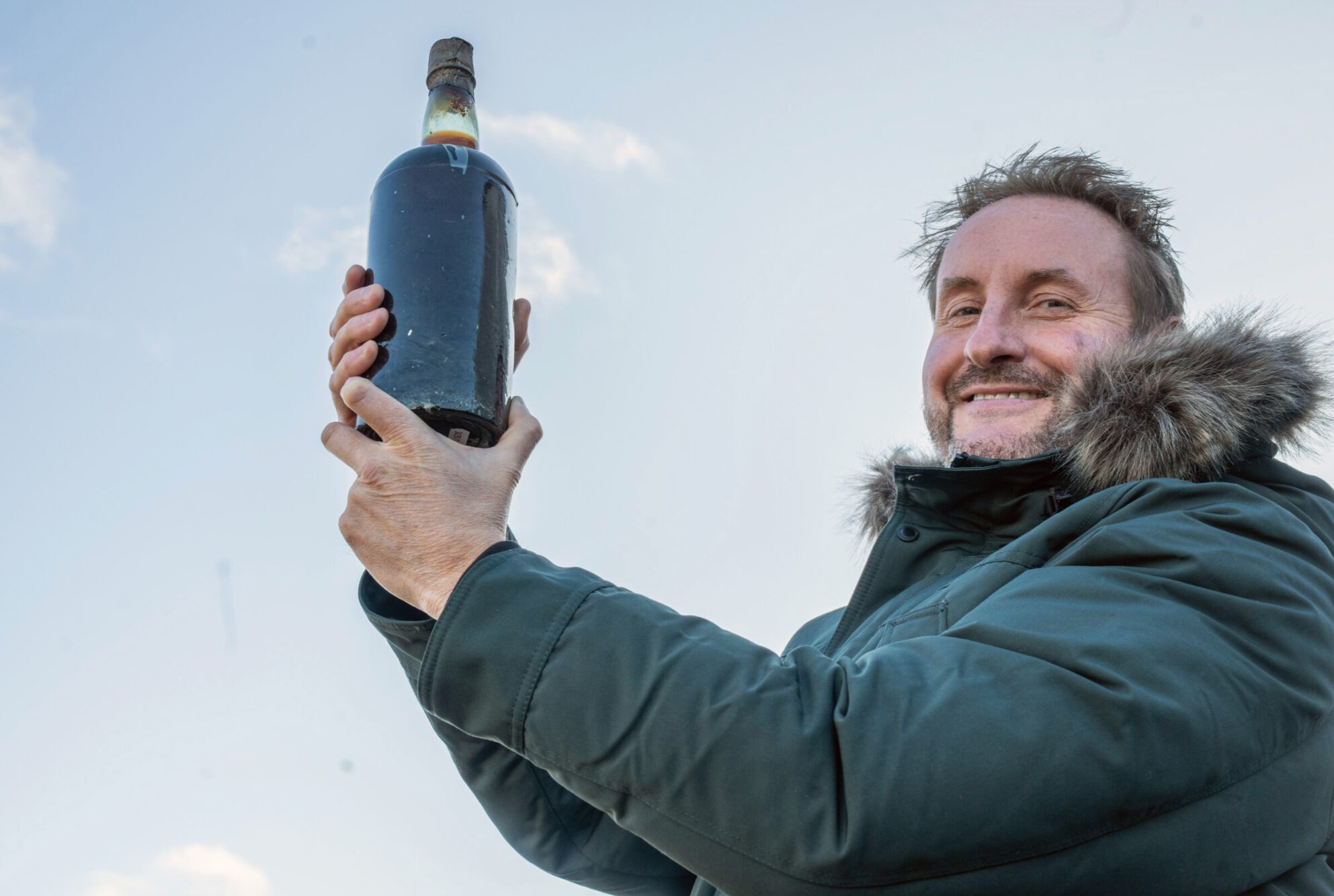 Dougal Gunn Sharp holding the 150-year-old Arctic Ale.