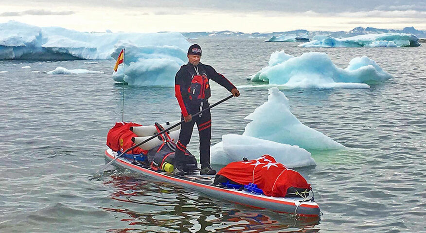 man on stand-up paddleboard in ice-choked Arctic waters
