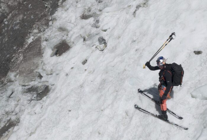 Bargiel on skis on a thin layer of old snow at a steep slope.