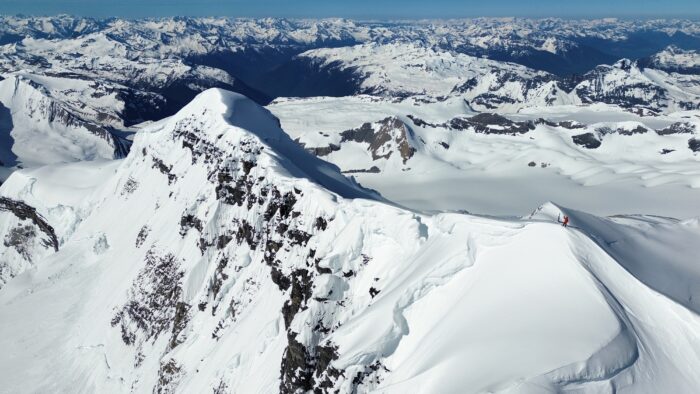 A climber on a snow covered summit in the Canadian Rockies