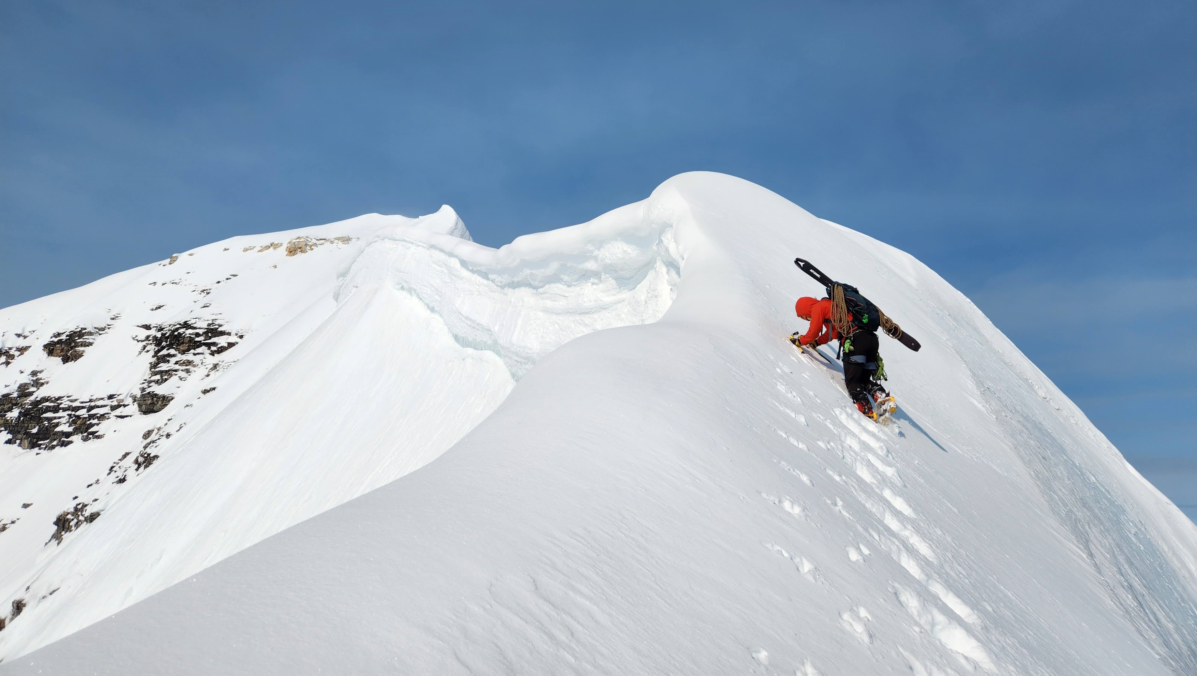 climber about to summit snowy peak
