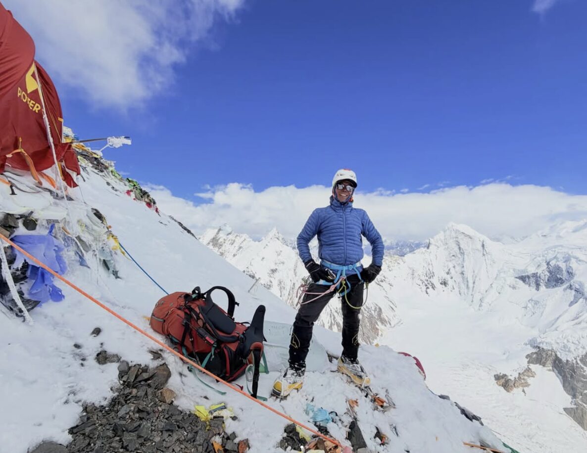 A sherpa by some tents on a steep slope on K2.
