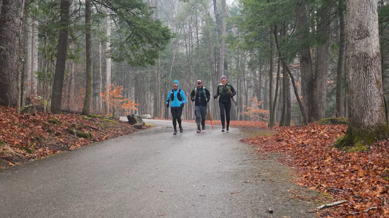 Three men running on a road in the woods