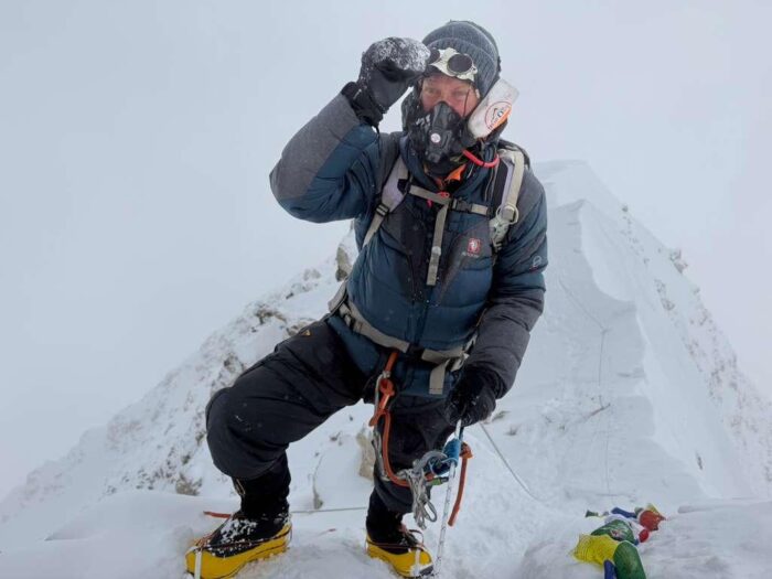 A climber with O2 on a mountain in a snowy day. 
