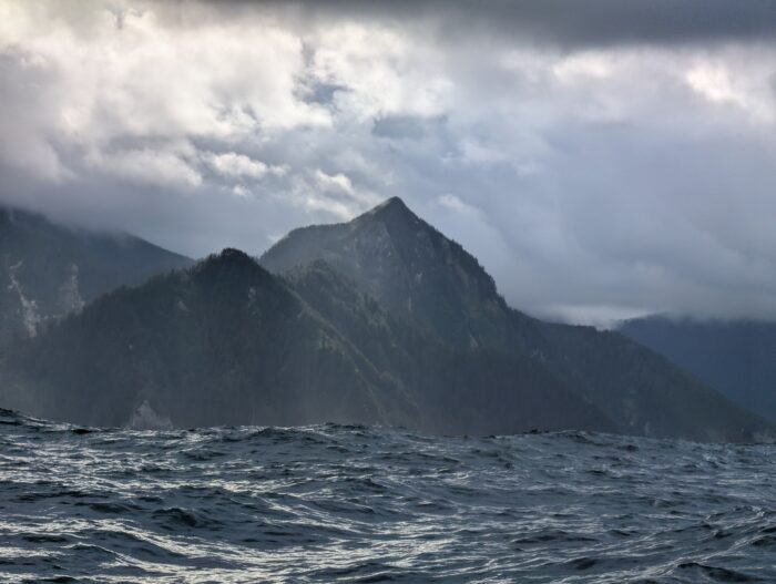 Swelling seas in front of steep cliffs on the western coast of Moresby Island, British Columbia