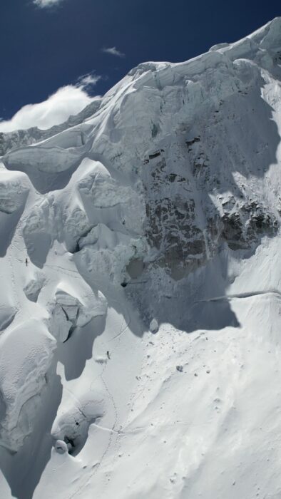 A line of tracks ona steep, snowy mountain face. 