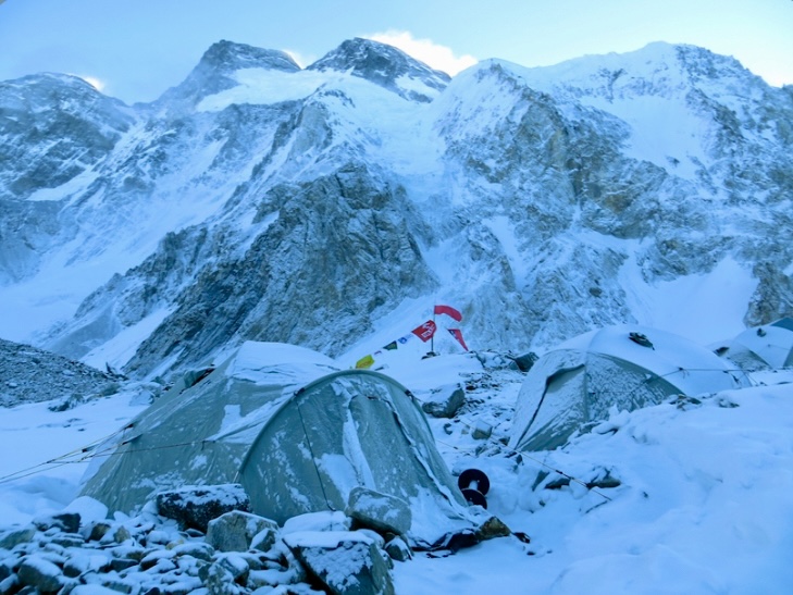 Broad Peak Base Camp in bleak winter after a storm. The standard route, followed by the 2013 Polish team that made the first winter ascent of the mountain, climbs the prominent col (above the foreground tent) and then up to the main summit on the right.