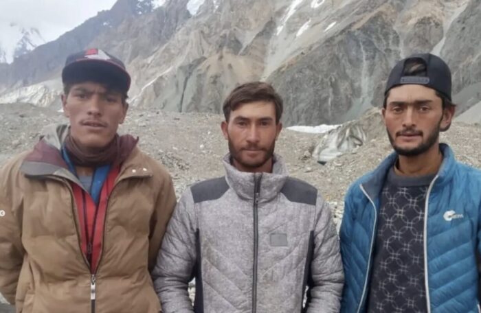 Close shot of three locals from Hunza, with the Karakoram in background. 