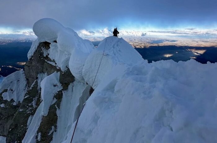 A climber on a heavily corniced ridge in Andes.