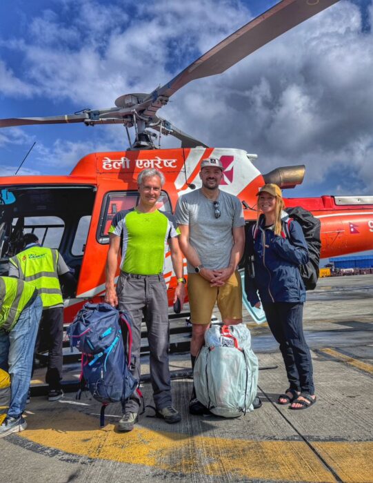People standing in front of a helicopter.