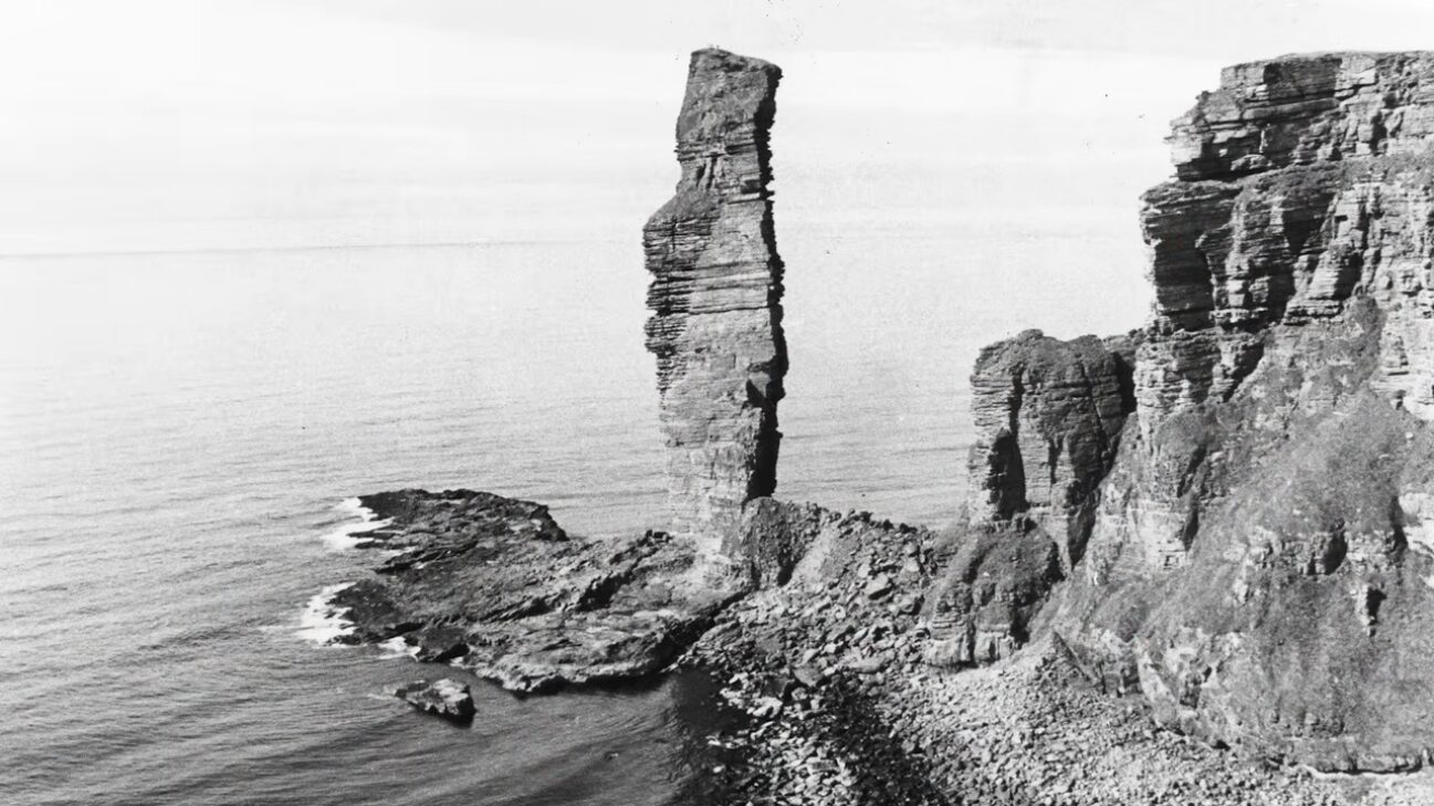 Black and white photo of a towering sea stack